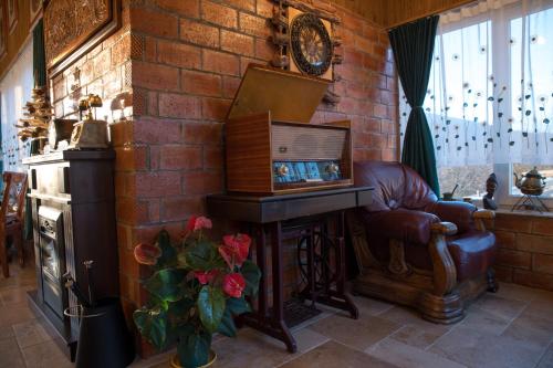 a living room with a piano and a chair and a brick wall at ȘURA LU' PĂTRU in Vulcan