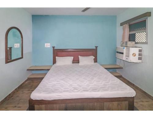 een slaapkamer met een groot bed in een blauwe kamer bij Hotel Dharamlok,Agra in Agra