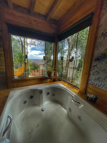 a bath tub in a room with a window at Recanto Lira 2 in Monte Verde