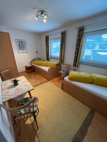Sala de estar con 2 camas y mesa en Landhaus Roland, en Umhausen