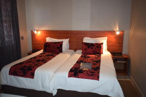 Habitación de hotel con 2 camas con almohadas rojas en Scenery Guesthouse Stadium, en Maseru