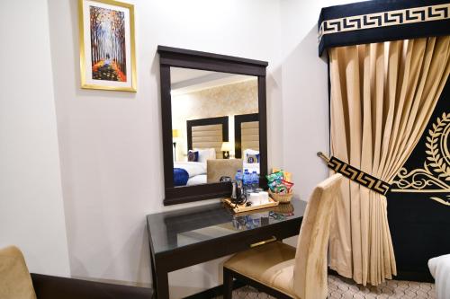 a hotel room with a desk and a mirror at Royal Regency Hotel in Islamabad