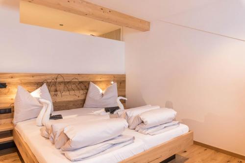 a bedroom with a bed with white pillows at Planerhof Apartment Edelweiss in Funes