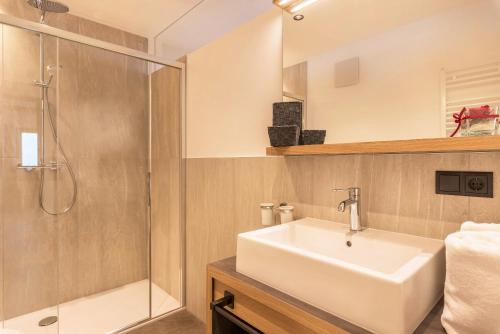 uma casa de banho com um lavatório e um chuveiro em Planerhof Apartment Edelweiss em Funes