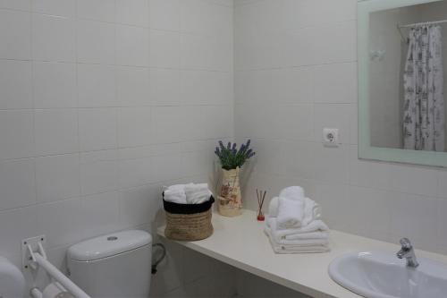 a bathroom with a sink and a toilet and towels at Cabañas Ecoparque Marín in Marín