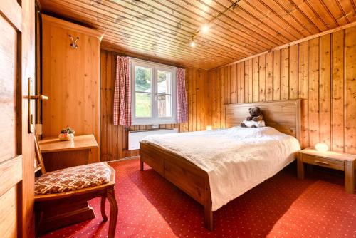 a bedroom with a bed in a wooden room at Berghaus Tschengla by A-Appartments in Bürserberg