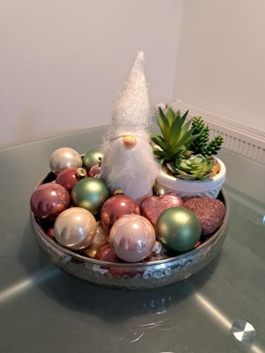 a bowl of christmas ornaments on a table at Apartman Megolina in Varaždin