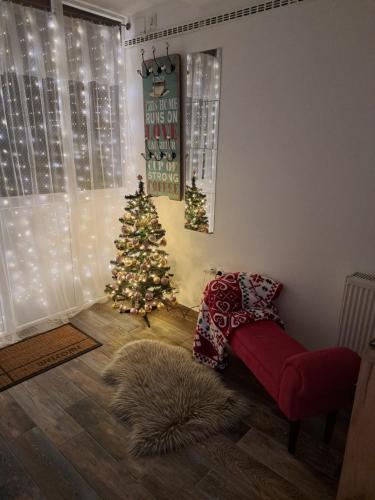 a living room with a christmas tree and a couch at Apartman Megolina in Varaždin