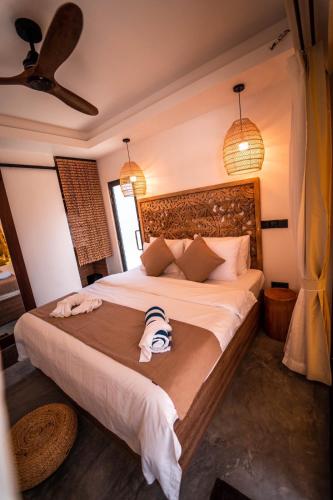 a bedroom with a bed with two towels on it at kunaa beach Inn in Fulidhoo