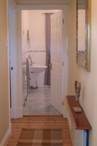 a bathroom with a white tub and a sink and a toilet at Cheviot View - Newton by the Sea, Northumberland in Alnwick