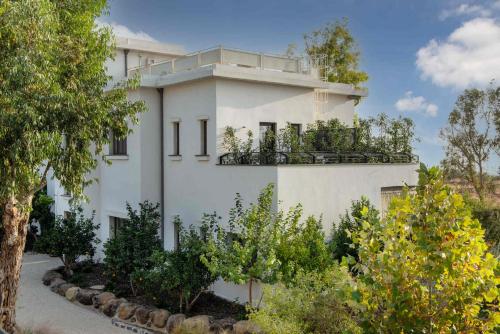a white building with a balcony on top of it at Pereh Mountain Resort in Gadot
