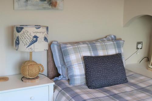 a bedroom with a bed with a pillow and a lamp at Cheviot View - Newton by the Sea, Northumberland in Alnwick