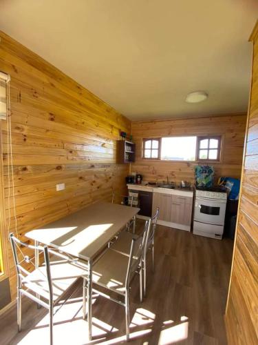 eine Küche mit einem Tisch und Stühlen im Zimmer in der Unterkunft Cabañas del Llano in Puyehue