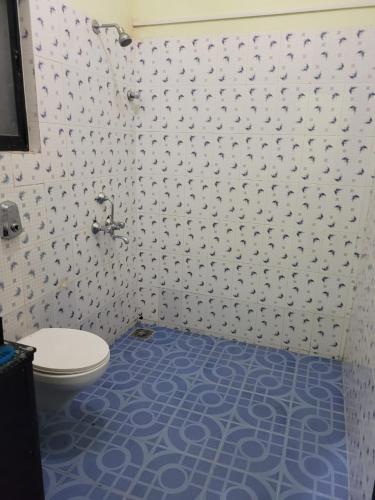 a bathroom with a toilet and a blue floor at Sunshine Park Homes in Colva