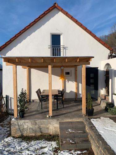 a wooden pergola with a table in front of a house at gemütliches Einfamilienhaus in Gera mit 3 Schlafzimmern mit Garten und Parkplatz in Gera