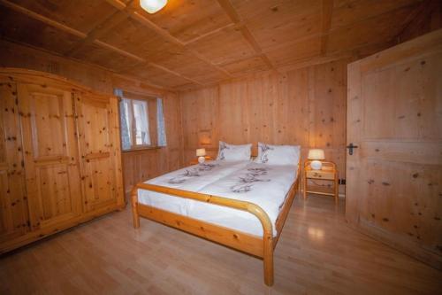 a bedroom with a bed in a wooden cabin at Hotel und Restaurant Alpina in Savognin