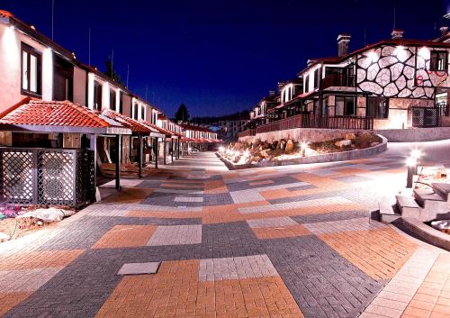 a cobblestone street in a town at night at Ruskovets Thermal SPA & Ski Resort in Bansko