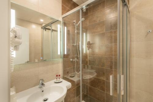Un baño con ducha, lavabo y espejo. en Pinar Malaga Centro C/Alvarez, en Málaga
