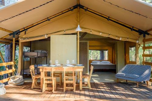 Zelt mit Tisch und Stühlen auf einer Terrasse in der Unterkunft Camping Maremma Sans Souci in Castiglione della Pescaia