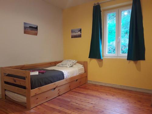1 dormitorio con cama de madera y ventana en Arrigorri Ostatu Jatetxea, en Ondárroa
