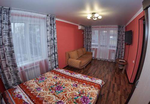 1 dormitorio con 1 cama, 1 silla y 1 ventana en Триумф, en Petropavlovsk