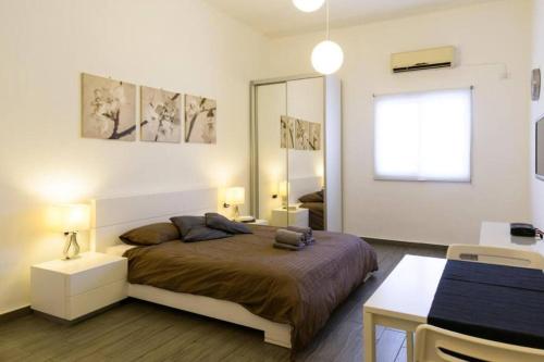 Schlafzimmer mit einem Bett, einem Schreibtisch und einem Spiegel in der Unterkunft Romantic Studio Diz Frishman in Tel Aviv