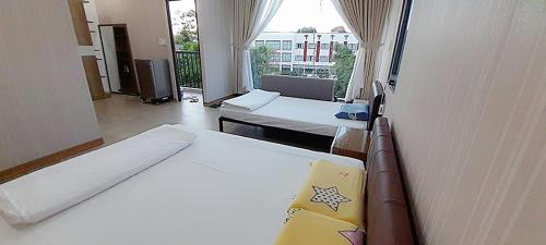Habitación con 2 camas y ventana grande. en Đồi Sao Homestay, en Buon Ma Thuot