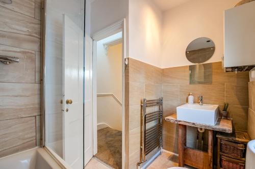 a bathroom with a sink and a shower at Lovely place, perfect for family and business travellers ideally located between the commons in London