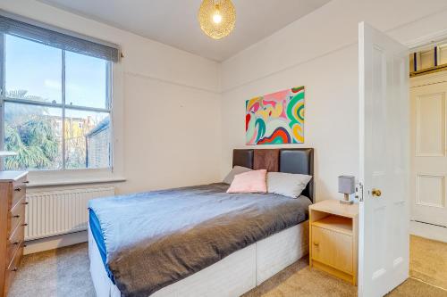 a bedroom with a bed and a window at Lovely place, perfect for family and business travellers ideally located between the commons in London