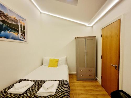 a bedroom with a bed with two towels on it at London Stay Apartments in London