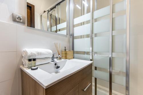 a bathroom with a sink and a mirror at BNBHolder Bright Plaza España in Madrid