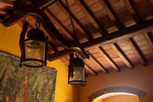 three lights are hanging from the ceiling of a room at La Rimbecca Greve in Chianti in Greve in Chianti