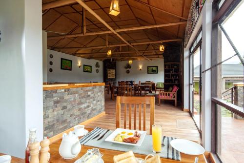 a dining room with a table with a plate of food at Lake Chahafi Resort in Kisoro