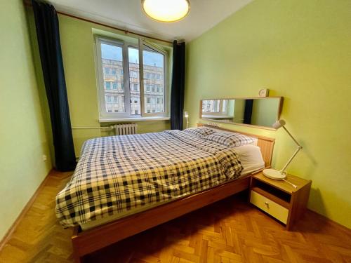 een kleine slaapkamer met een bed en een raam bij RAVEN metro fast WiFi 70’TV Netflix HBOmax AppleTV in Warschau