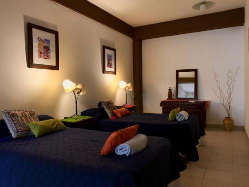 Habitación de hotel con 2 camas y espejo en Ayllu en Salta