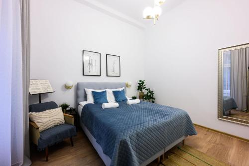 1 dormitorio con 1 cama azul y 1 silla en Unique Style Apartments Old Town - 25 min from the airport - by Homelike Krakow, en Cracovia