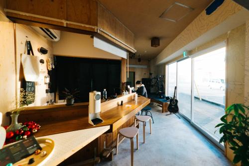 a room with a bar with stools and a large window at SLEEEP JP Fujinomiya in Fujinomiya