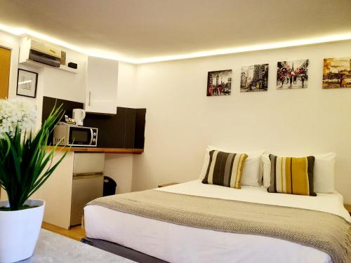 a hotel room with a bed and a microwave at London Stay Apartments in London