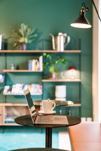 a table with a laptop and a cup on it at B2 Hotel Zürich in Zürich