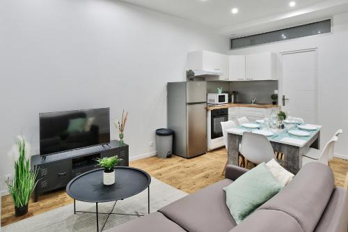 un salon avec un canapé et une table dans l'établissement Appartement Le Cocon Lyonnais, à Villeurbanne