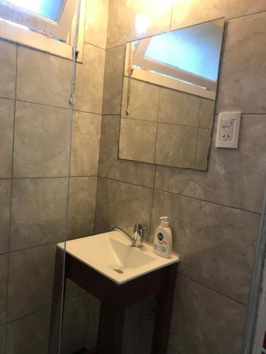 een badkamer met een wastafel en een spiegel bij Departamento Mar del Plata, La Perla in Mar del Plata
