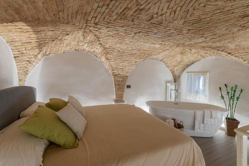 sypialnia z dużym łóżkiem i wanną w obiekcie L'ira di Dante w mieście Gubbio