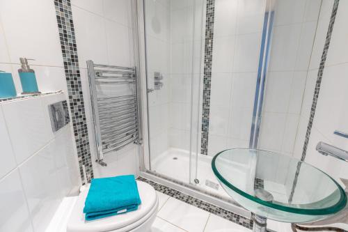 a bathroom with a toilet and a glass shower at Camden Town apartments in London