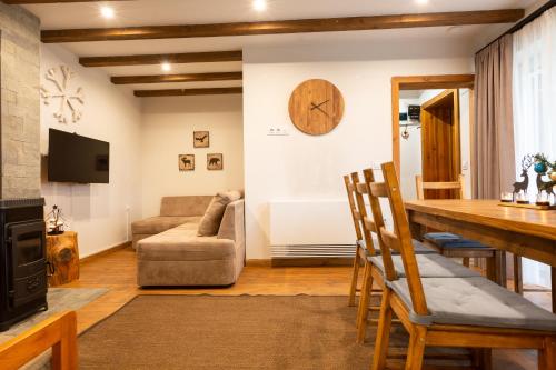 uma sala de estar com uma mesa e um sofá em Къщи за гости Сноуфлейк Snowflake Chalet and Snowflake Lodge em Bansko