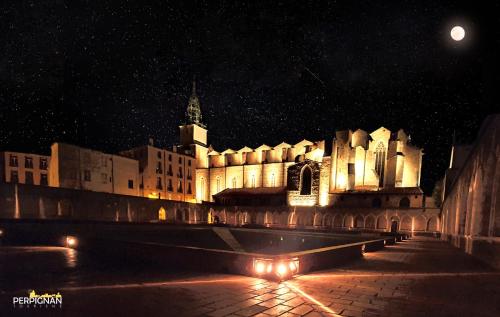 a large building at night with the moon behind it at ibis budget Perpignan Centre Rénové en 2025 in Perpignan
