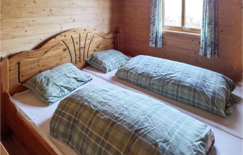 two beds in a log cabin with a window at Awesome Home In Auklandshamn With 4 Bedrooms 