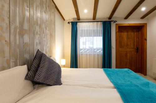 a bedroom with a white bed and a window at Къщи за гости Сноуфлейк Snowflake Chalet and Snowflake Lodge in Bansko