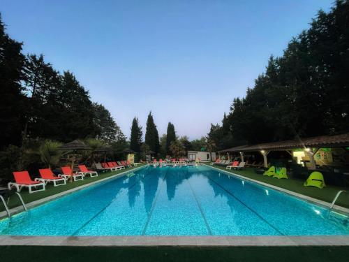 a large swimming pool with lounge chairs at Les hebergements Insolites in Taradeau