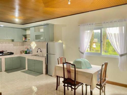 La cuisine est équipée d'une table, de chaises et d'un réfrigérateur. dans l'établissement Villa Nada Situgunung., 