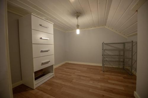 an attic room with a dresser and a shelf at Abisko Guesthouse & Activities in Abisko